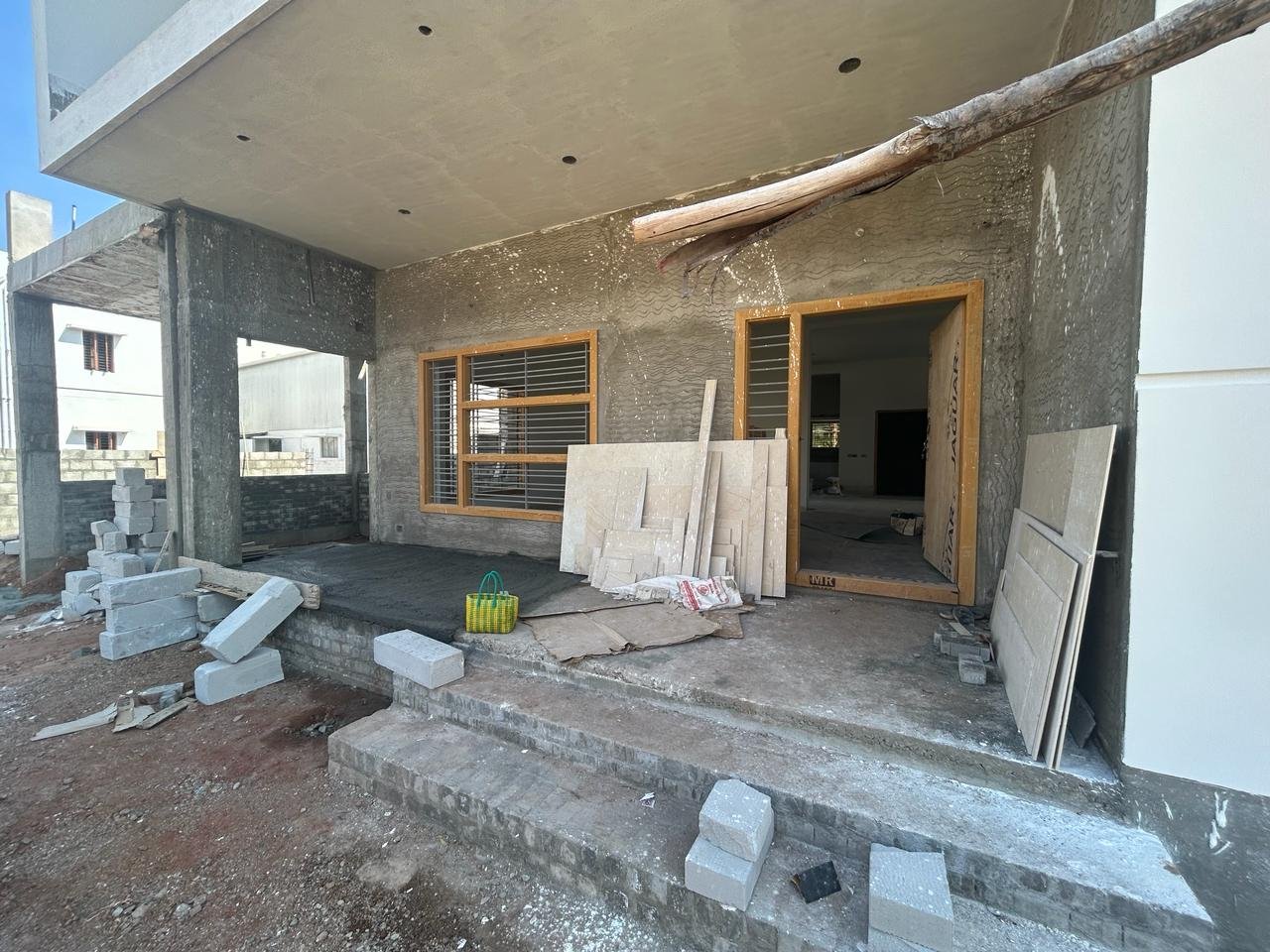 Residence under construction with wood facade cladding and car parked outside