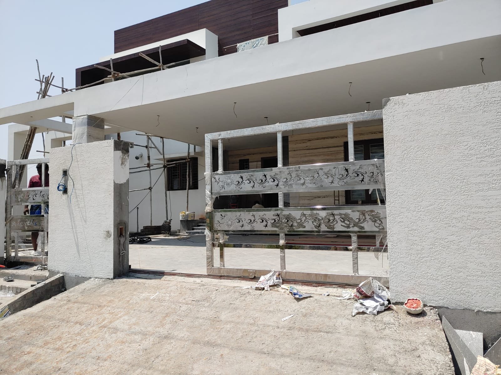 Villa entrance with stainless steel decorative gate and compound wall