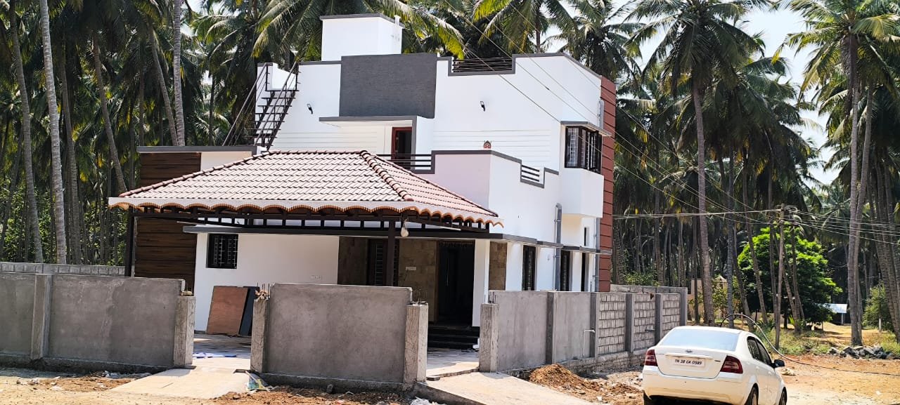 Side view of a completed villa surrounded by coconut trees